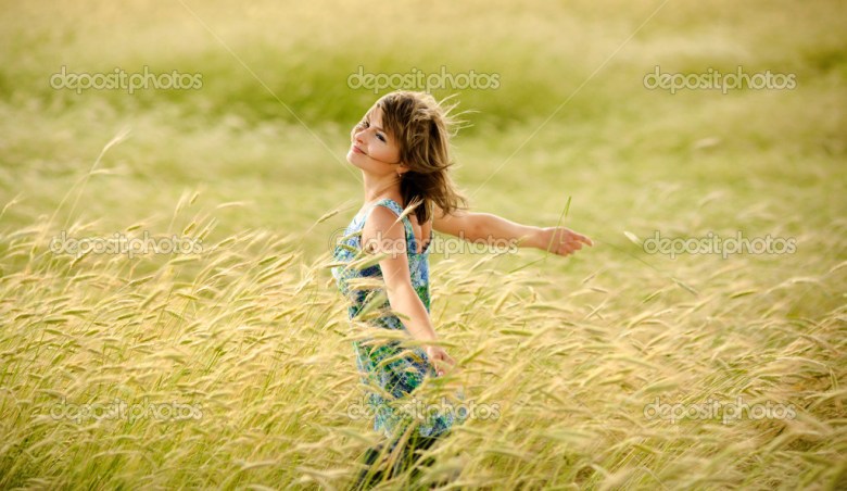 beautiful girl smiling in a field of wheat